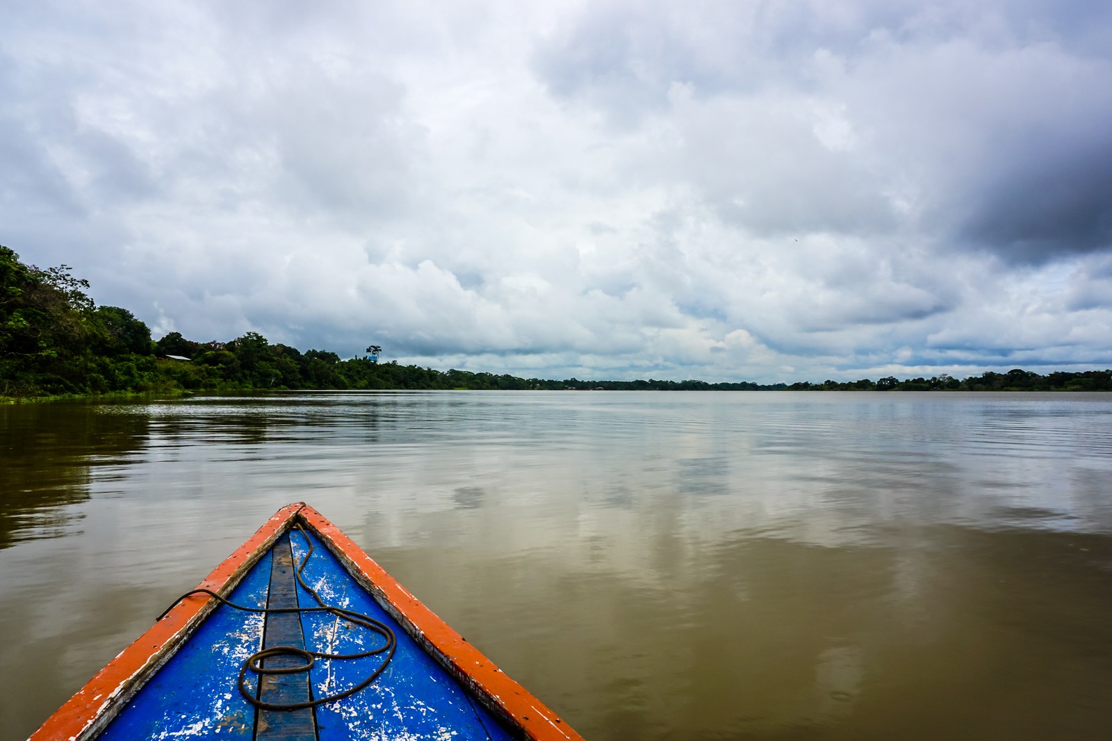 Laguna de Yarinacocha cerca de Pucallpa, con agua oscura, vegetación densa y cielo nublado