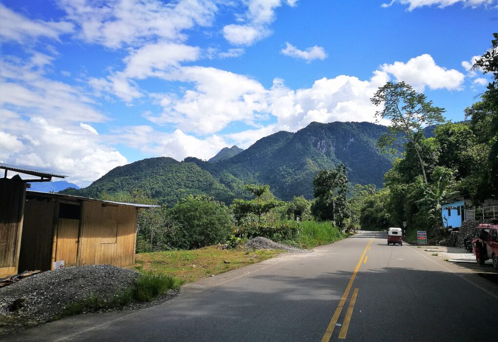 Carretera entre la vegetación hacia la montaña de la Bella Durmiente, en Tingo María (Huánuco), con cielo azul