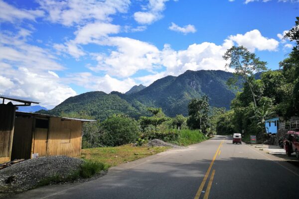 Carretera entre la vegetación hacia la montaña de la Bella Durmiente, en Tingo María (Huánuco), con cielo azul