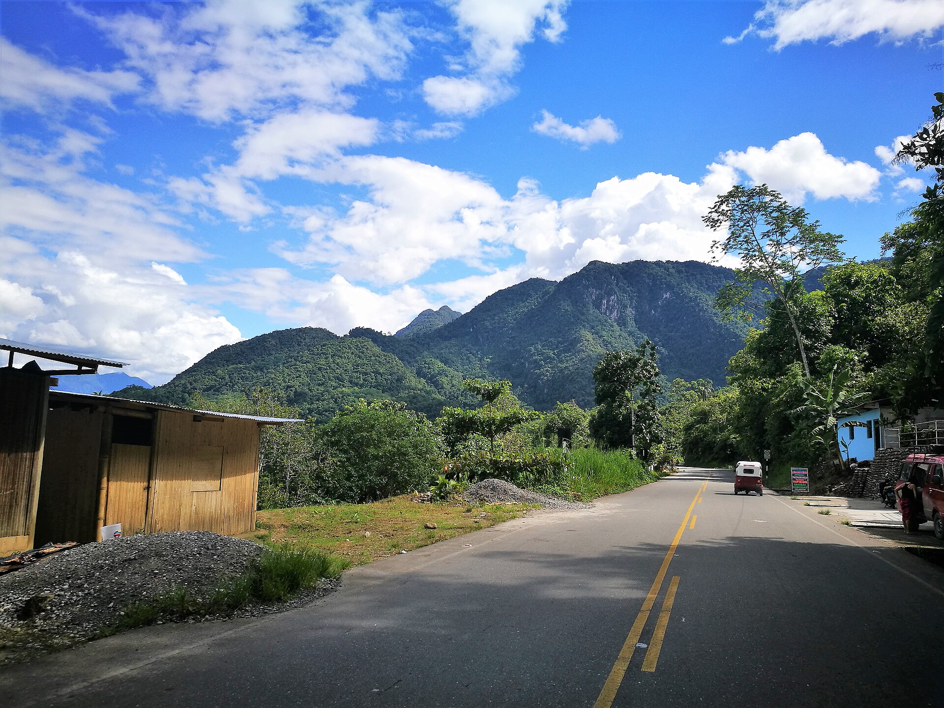 Carretera entre la vegetación hacia la montaña de la Bella Durmiente, en Tingo María (Huánuco), con cielo azul