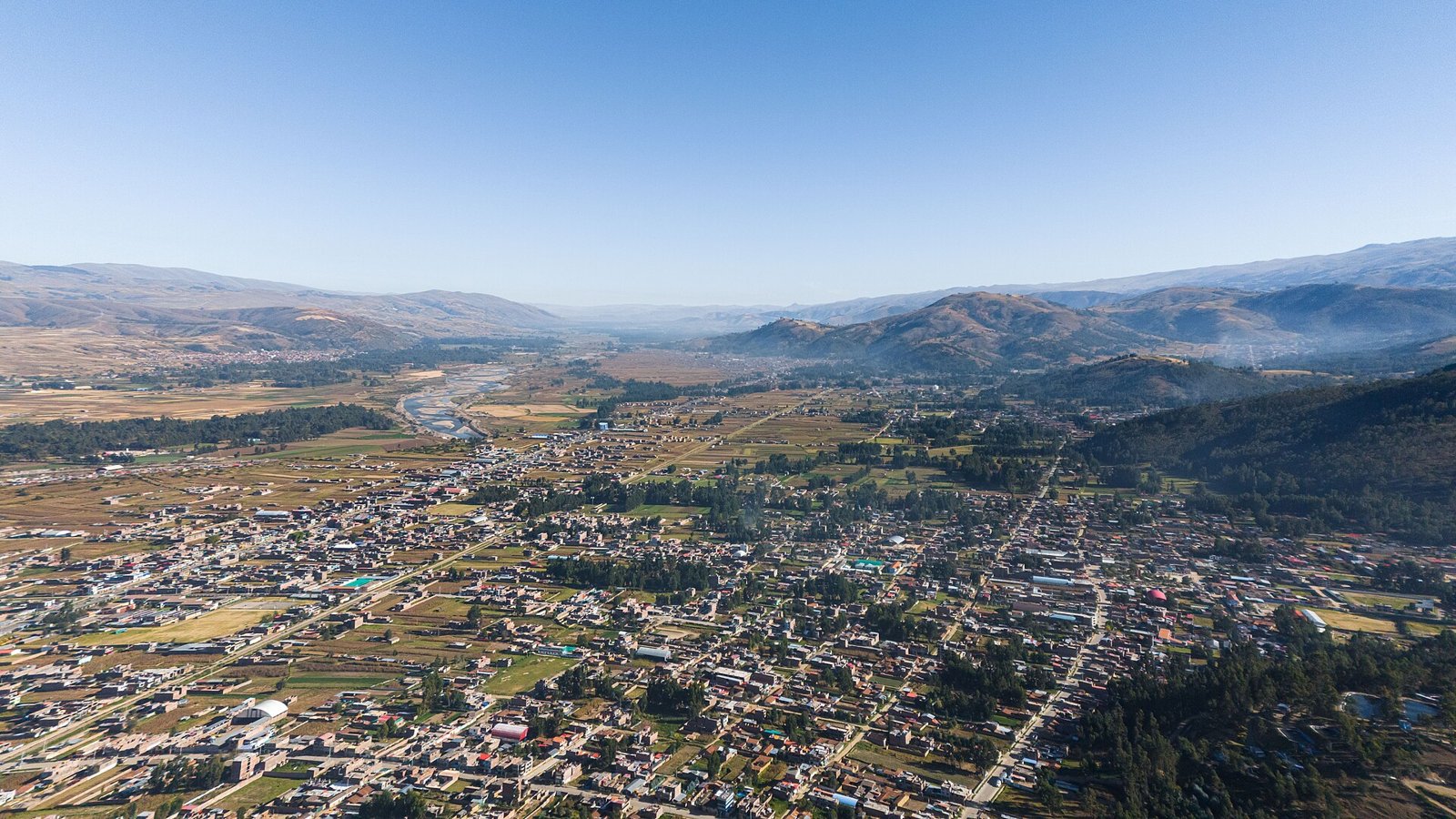Vista aérea del Valle del Mantaro desde Concepción, con casas, chacras, el río y cerros al fondo